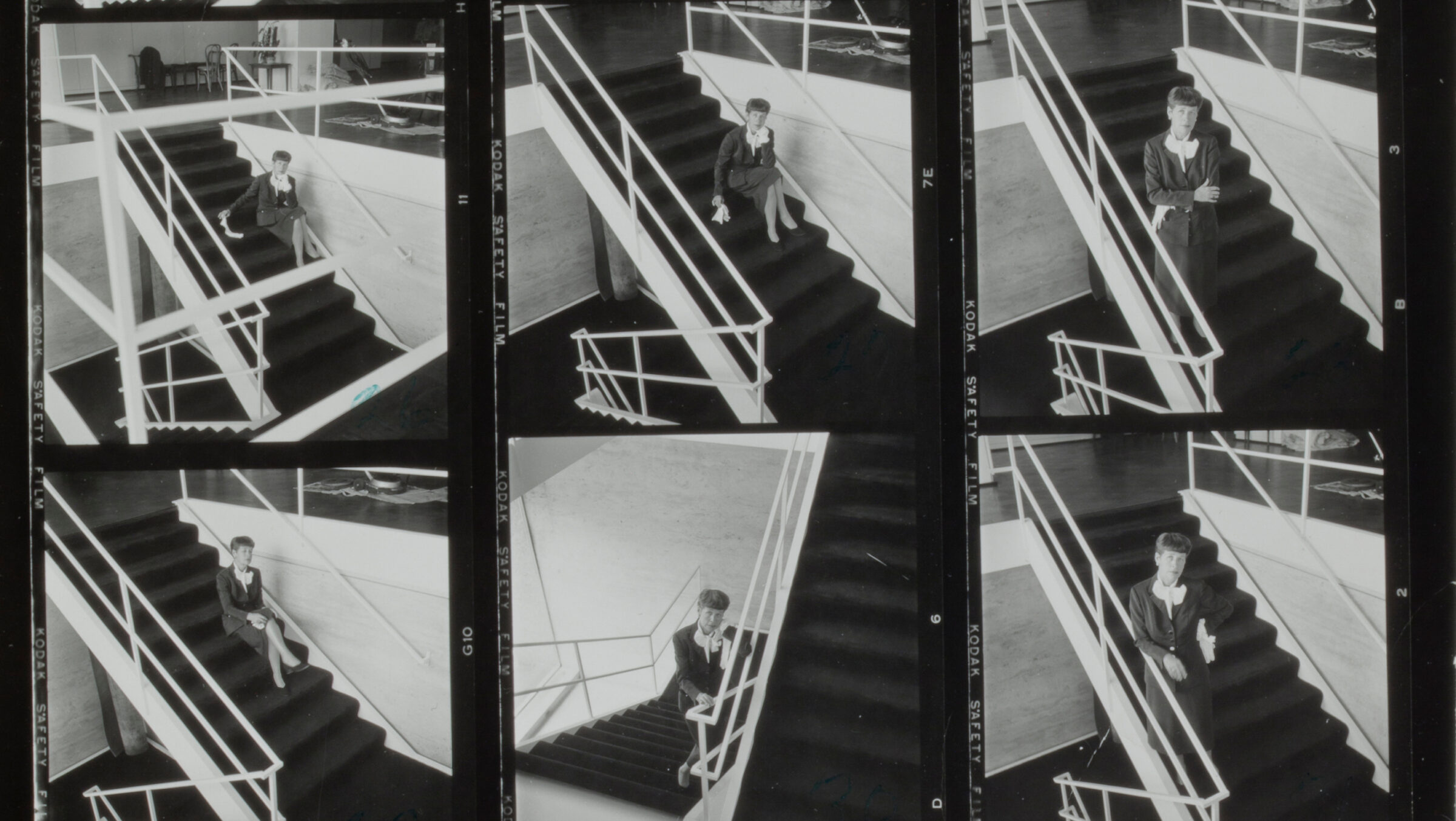 A series of 6 black and white photographs Rue Winterbotham Shaw posing on a large white Mies van der Rohe staircase with black carpeted steps.