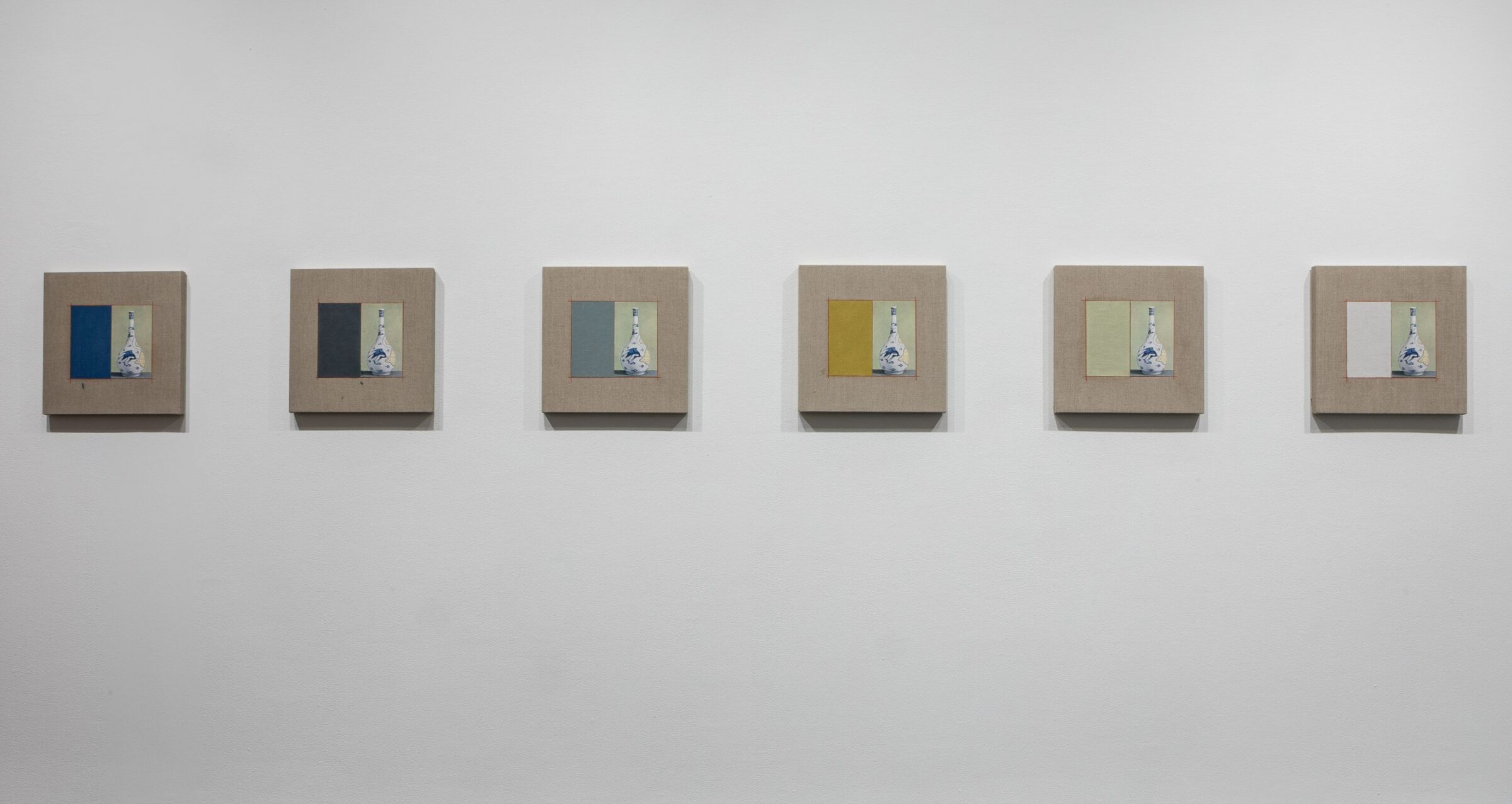 A series of six small square paintings of a decorative bottle arranged in a line on a white gallery wall.