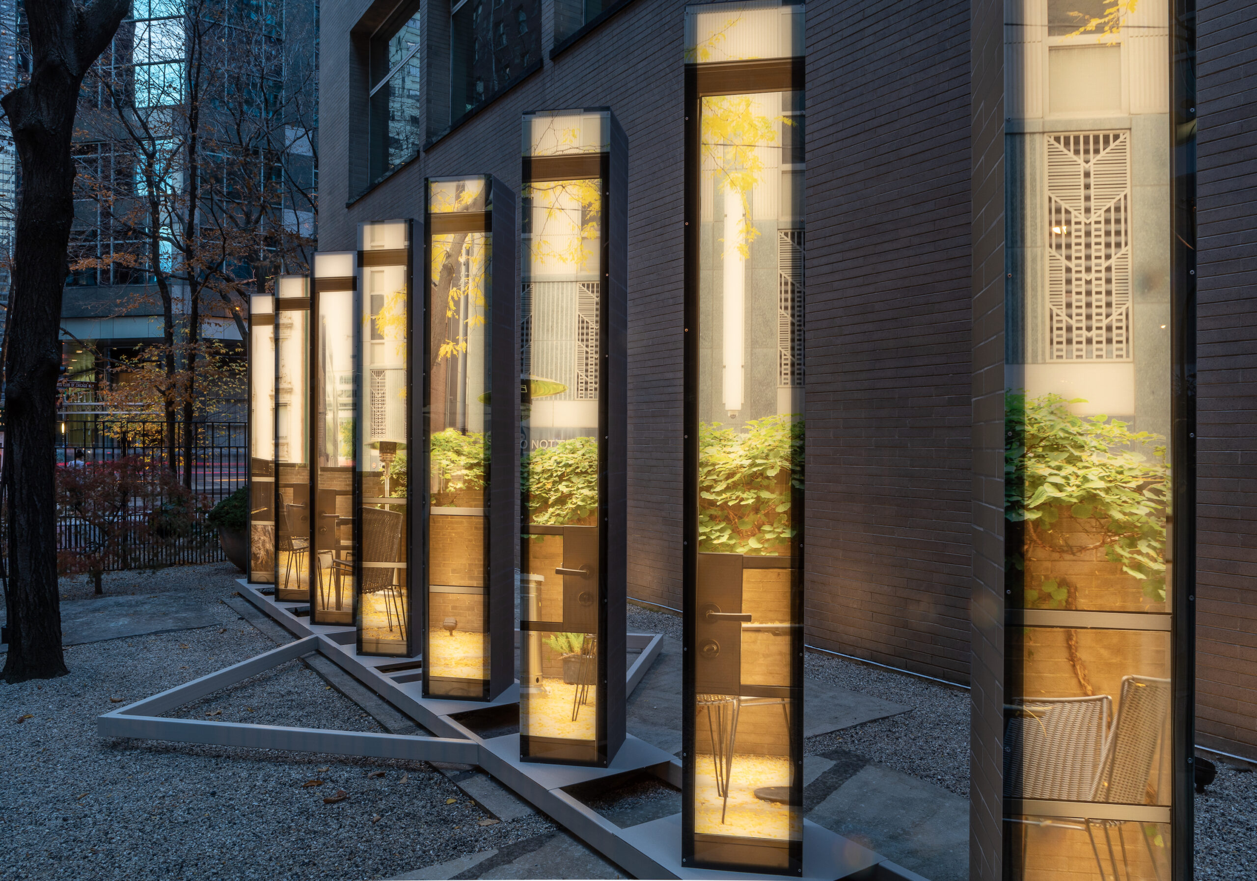 Installation of seven square columns with the backlit image of a landscape on one side.