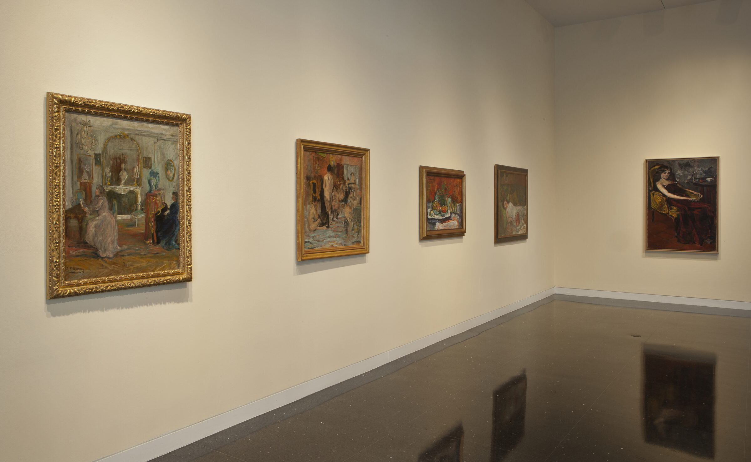 Corner of a gallery with five works hung on the walls.
