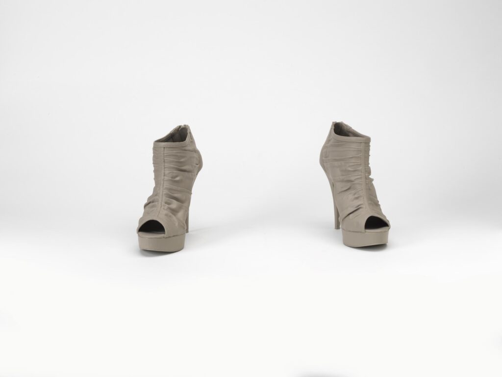 Peek-toe high heels in a greyish brown against a white backdrop.