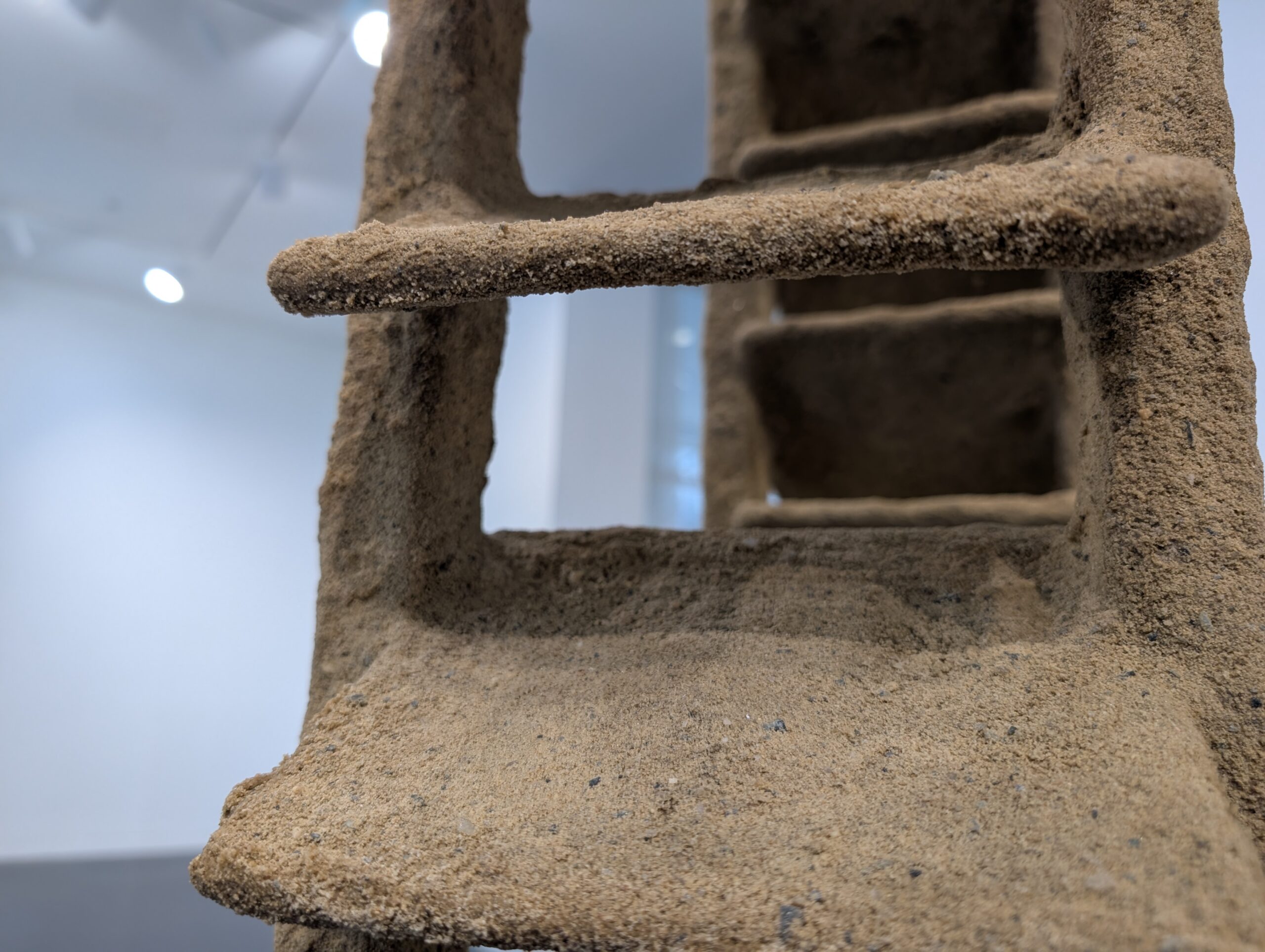 close-up image of a sand-covered sculpture evoking stairs